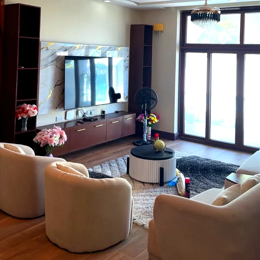 Spacious air-conditioned living room with TV wall and premium sofas